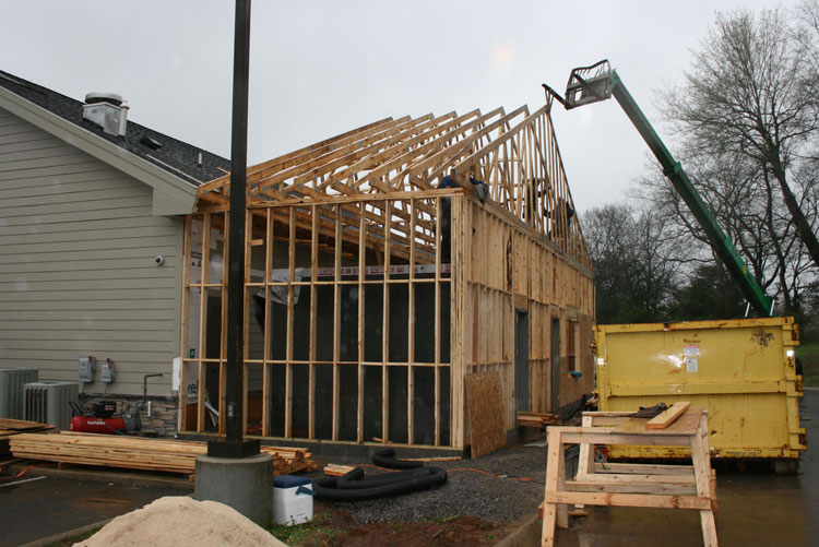 Residential home addition under construction with wood framing and roof trusses, showing the type of project homeowners may consider when researching Home addition builders, home addition companies, house extension builders near me, and home addition contractors.