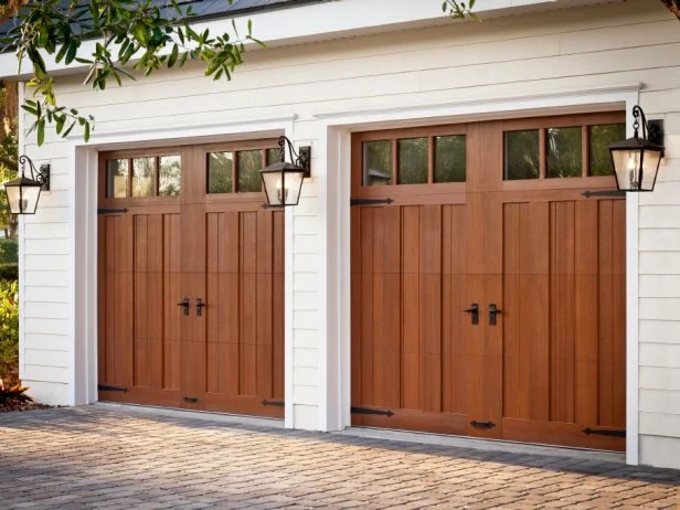 Garage door replacement near me featuring beautiful wood-style carriage doors with decorative windows for homeowners planning garage door replacement, comparing garage door replacement cost, selecting a replacement garage door, or looking to replace garage door systems.