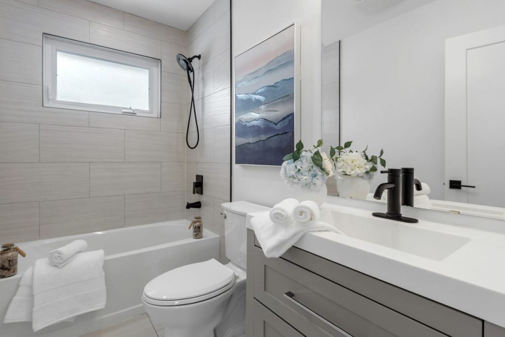 Modern remodeled bathroom featuring a tiled tub and shower, contemporary vanity, and updated fixtures by a Bathroom remodel company specializing in bath remodel, local bath renovation contractors, bathroom design and build firm, and bathrooom contractor near me services.
