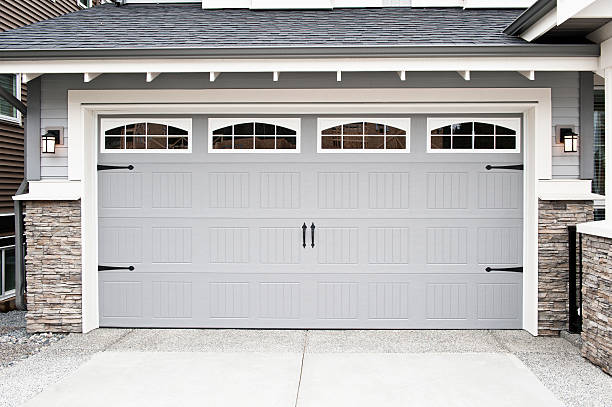 Garage door replacement near me featuring a white carriage-style door with decorative windows for homeowners planning garage door replacement, comparing garage door replacement cost, selecting a replacement garage door, or looking to replace garage door systems.