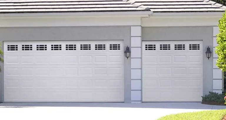Garage door replacement contractor installing white residential garage doors for homeowners searching best garage door replacement near me, garage door replace near me, and cost to replace garage door.