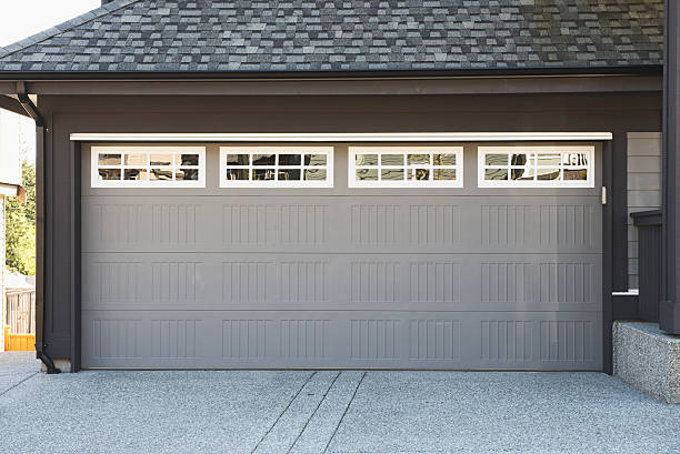 Garage door replacement near me featuring a modern gray door with decorative windows for homeowners planning garage door replacement, comparing garage door replacement cost, selecting a replacement garage door, or looking to replace garage door systems.